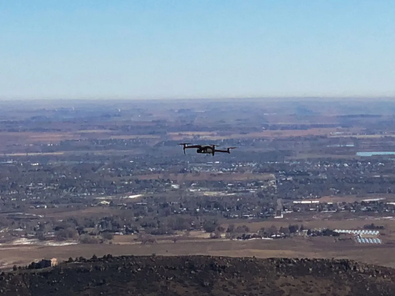 Drone flying over a broad valley with a town below