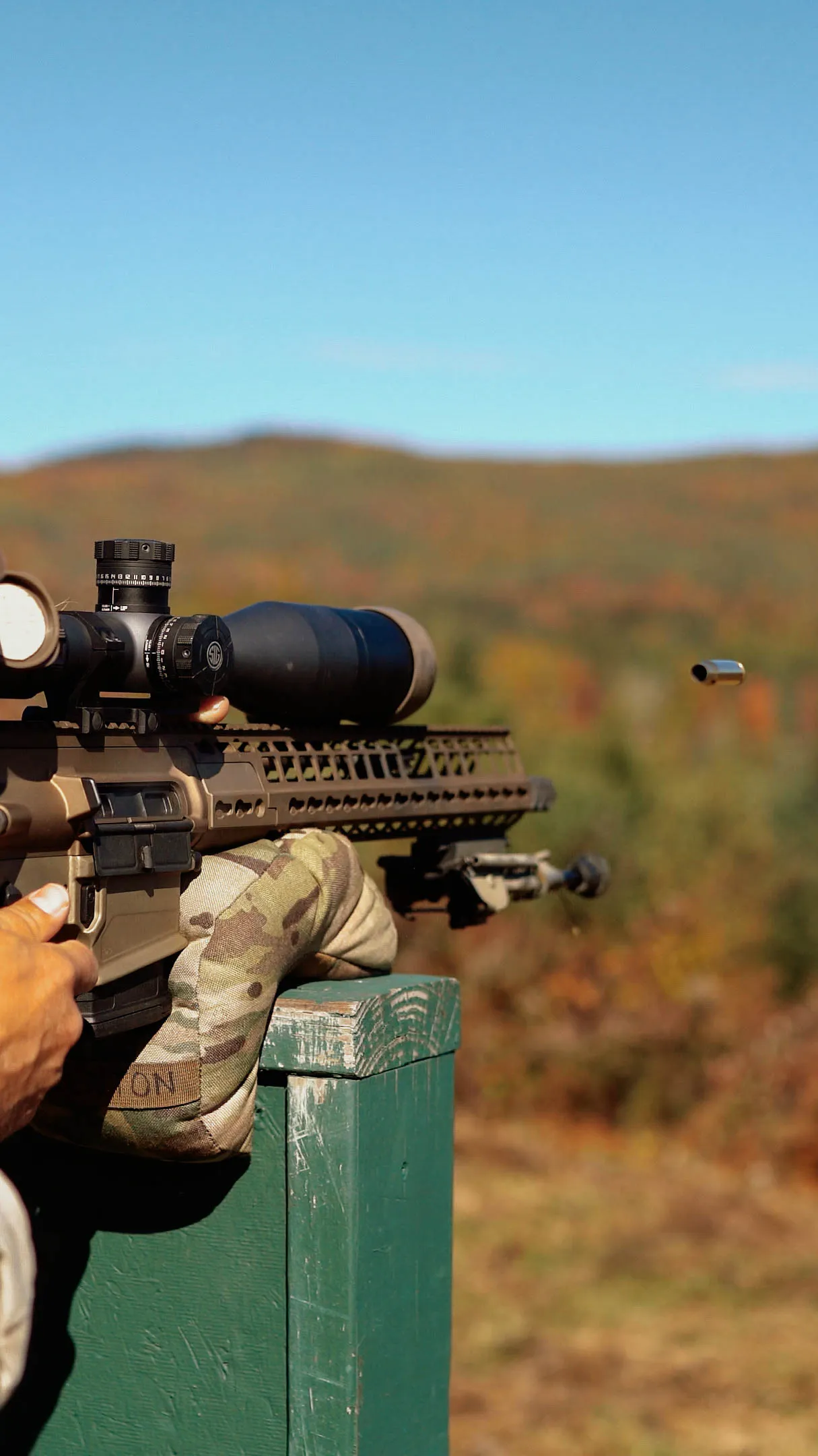 Spent casing ejecting from a precision rifle fired from a barricade