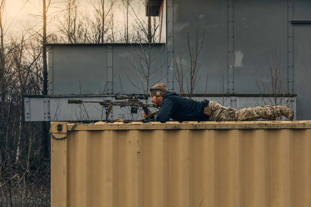 Shooter lying prone on top of a shipping container, aiming a precision rifle