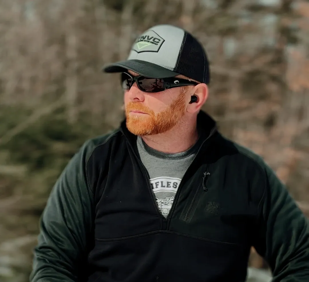 Portrait of the lead instructor in a cap and sunglasses at the range